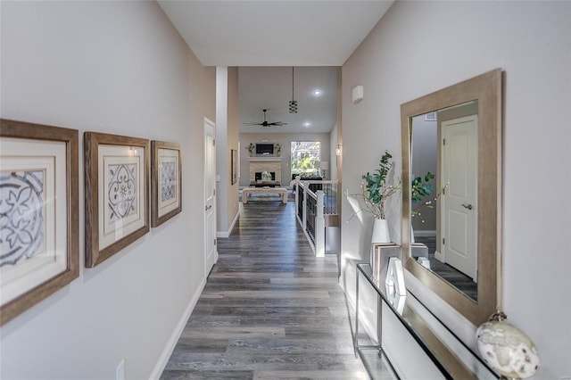 corridor featuring dark wood-style flooring and baseboards