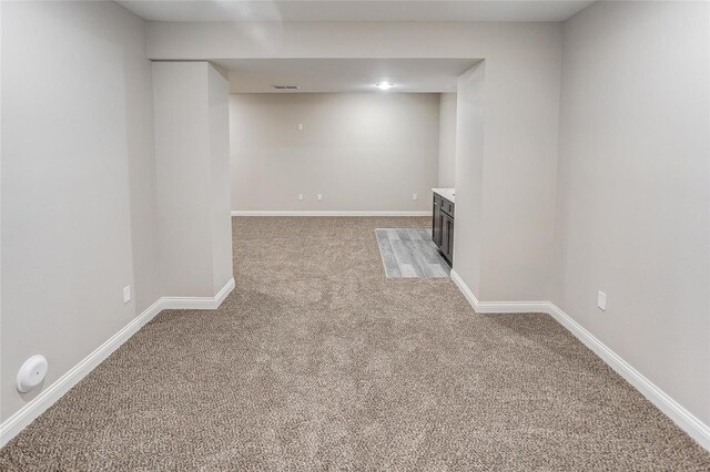 finished below grade area featuring light carpet and baseboards