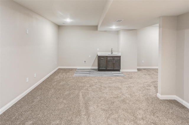 finished basement featuring light colored carpet and baseboards