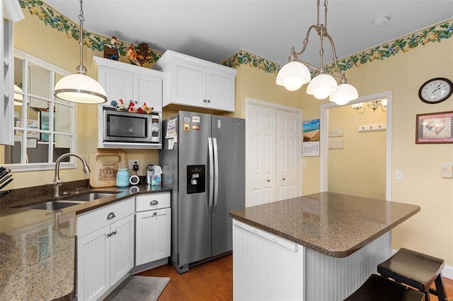 15 Mill St, Elsah, IL 62028 - kitchen with appliances with stainless steel finishes, a sink, dark wood-style flooring, white cabinetry, and hanging light fixtures