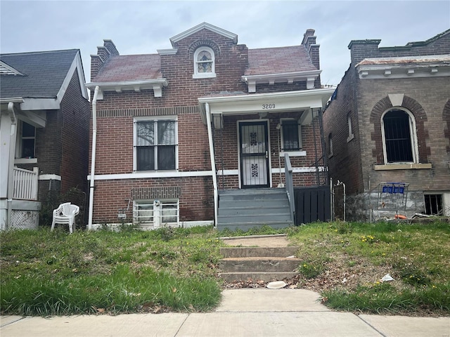 view of front facade with brick siding and a porch