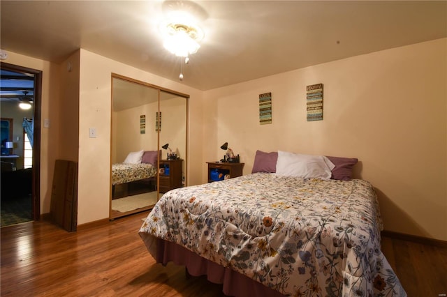 bedroom featuring wood finished floors, baseboards, and a closet