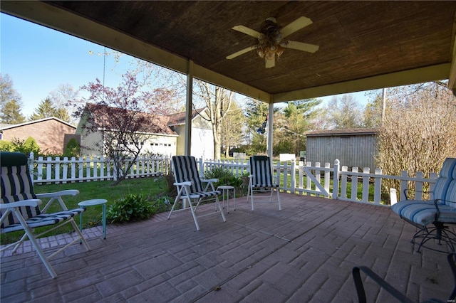 wooden terrace with fence, ceiling fan, and an outdoor structure