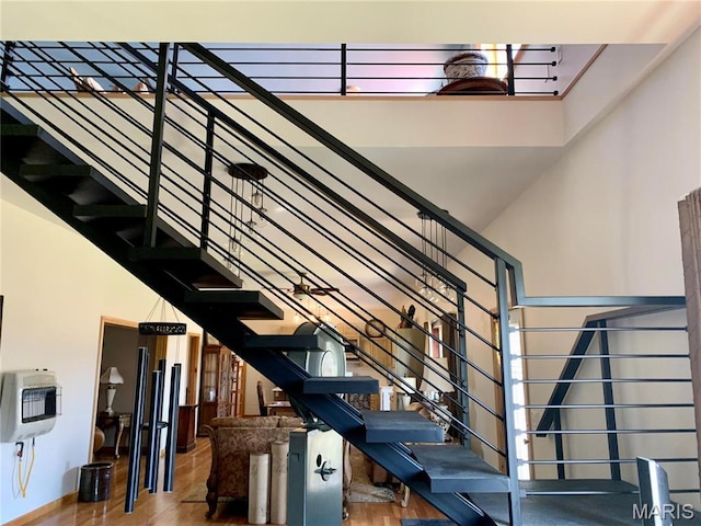 24613 Shady Oak Pl, Perry, MO 63462 - staircase featuring a towering ceiling, heating unit, wood finished floors, and baseboards