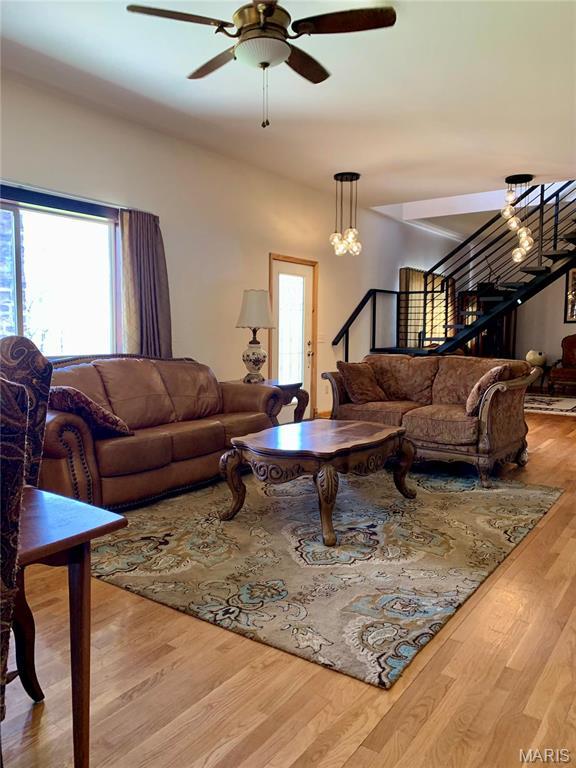 24613 Shady Oak Pl, Perry, MO 63462 - living room with plenty of natural light, a ceiling fan, wood finished floors, and stairway