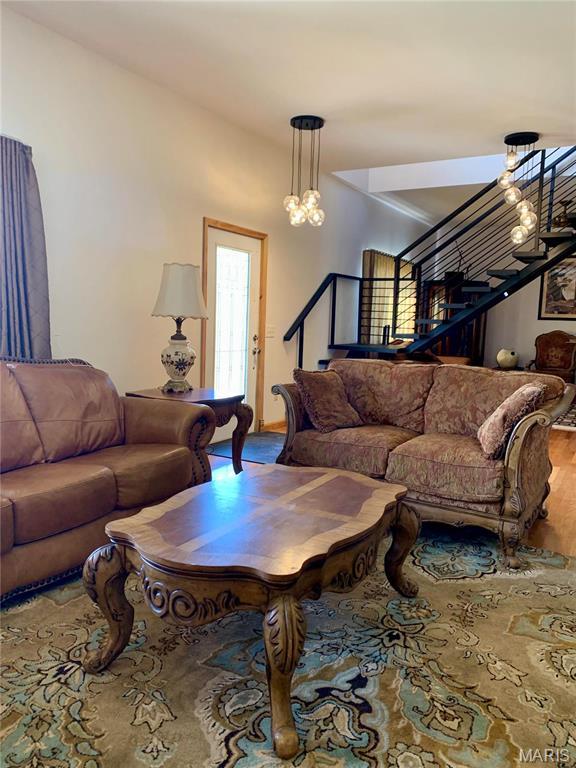 24613 Shady Oak Pl, Perry, MO 63462 - living area featuring stairs, a chandelier, and wood finished floors