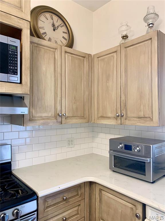 24613 Shady Oak Pl, Perry, MO 63462 - kitchen featuring stainless steel appliances, tasteful backsplash, light brown cabinetry, and wall chimney exhaust hood
