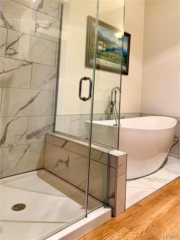 24613 Shady Oak Pl, Perry, MO 63462 - bathroom featuring a shower stall, a freestanding bath, and wood finished floors