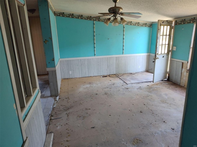 5226 Timber Lake Dr, Waterloo, IL 62298 - unfurnished room featuring ceiling fan, wainscoting, a textured ceiling, wood walls, and unfinished concrete flooring