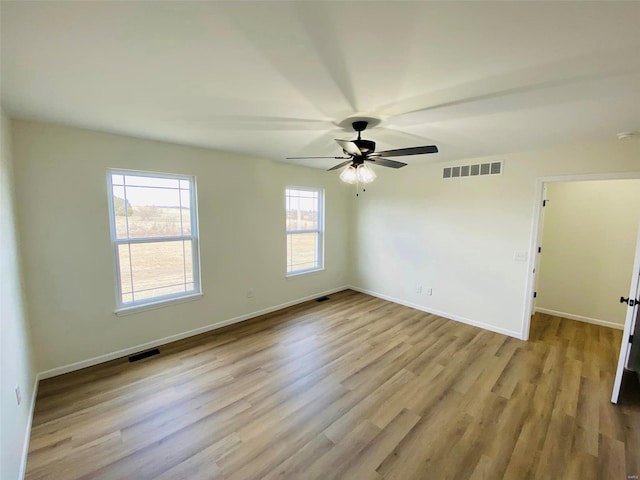 unfurnished room with wood finished floors, baseboards, and a ceiling fan