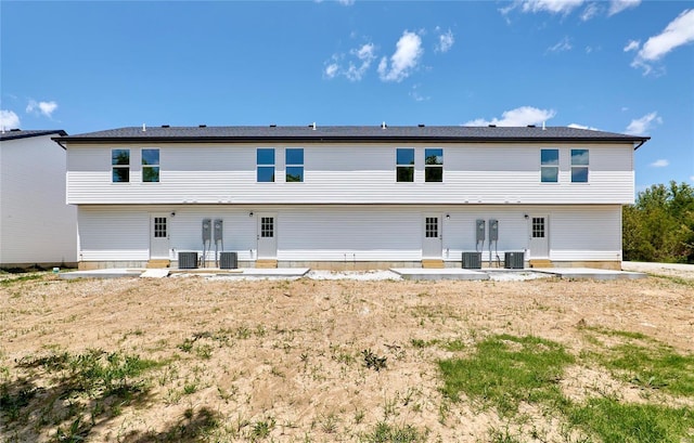 back of property with entry steps, central air condition unit, and a patio area