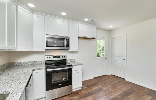 kitchen with appliances with stainless steel finishes, white cabinets, light stone countertops, dark wood-style floors, and recessed lighting