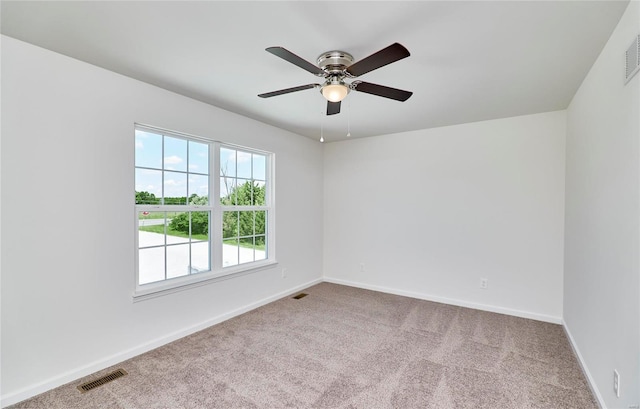 carpeted empty room featuring a ceiling fan and baseboards