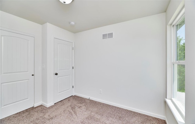 unfurnished bedroom featuring carpet flooring and baseboards
