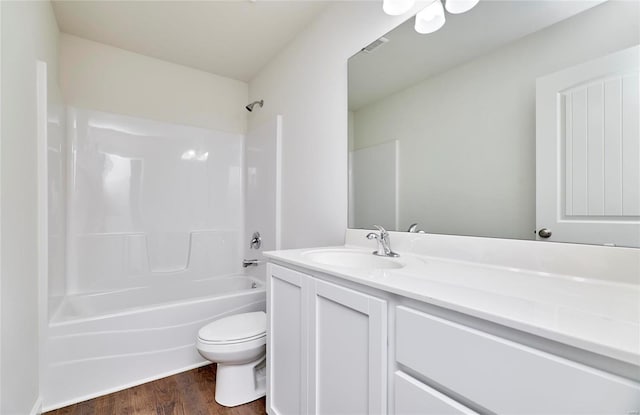 bathroom featuring wood finished floors, vanity, shower / washtub combination, and toilet