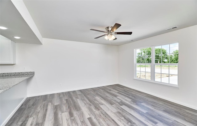 unfurnished room with wood finished floors, baseboards, a ceiling fan, and recessed lighting