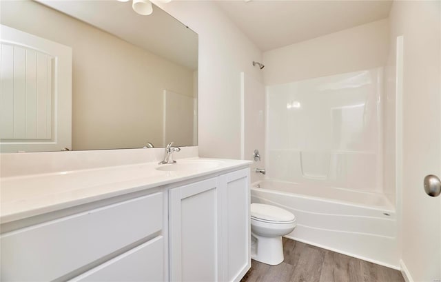 full bath featuring wood finished floors, toilet, vanity, and bathing tub / shower combination