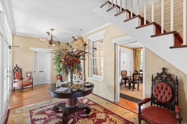 813 S 4th St, Clarksville, MO 63336 - entryway featuring wood finished floors, crown molding, stairway, and brick wall
