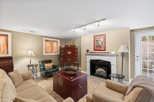 813 S 4th St, Clarksville, MO 63336 - living room featuring baseboards, rail lighting, and a fireplace