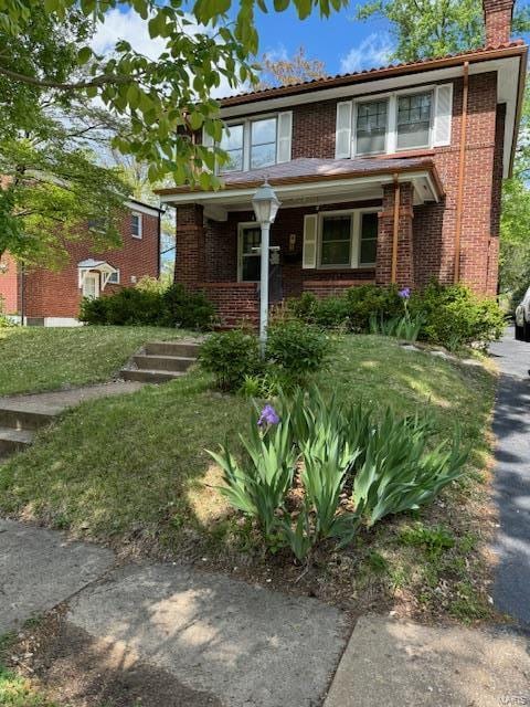 8245 Glen Echo Dr, Saint Louis, MO 63121 - view of front facade with a chimney, a tile roof, brick siding, and a porch