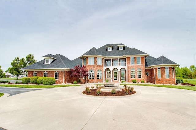 view of front of property featuring curved driveway and brick siding