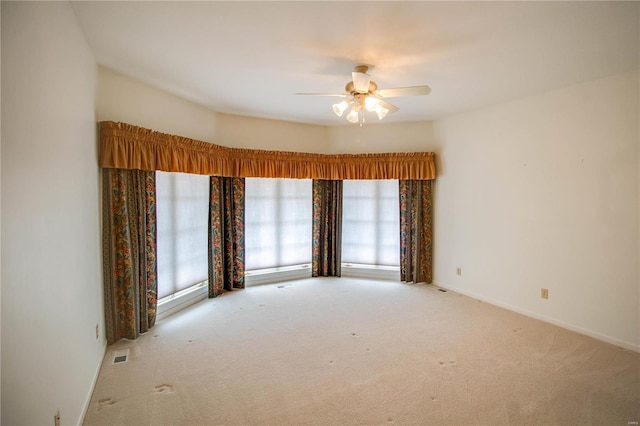 spare room with carpet, a ceiling fan, and baseboards