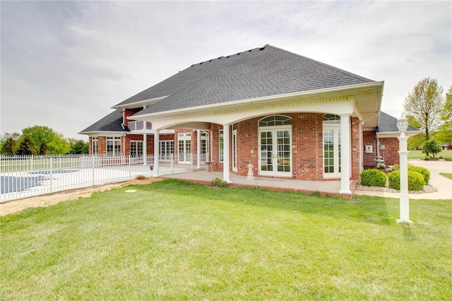 back of house with french doors, a shingled roof, brick siding, and a patio