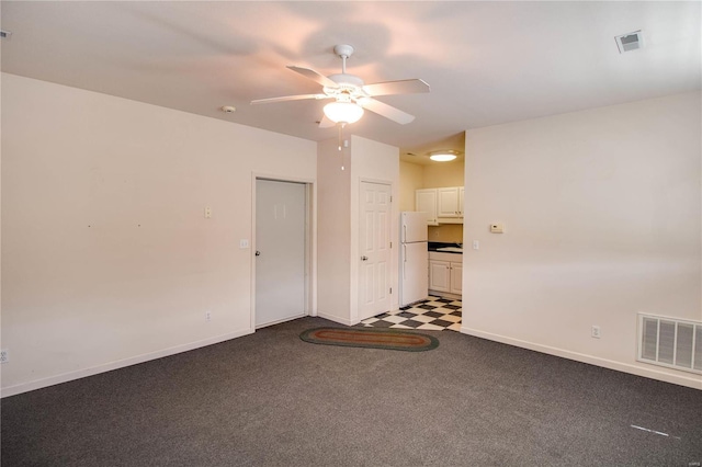 empty room with a ceiling fan, baseboards, carpet floors, and tile patterned floors