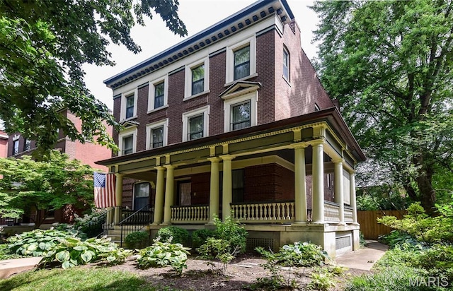5076 Westminster Pl, Saint Louis, MO 63108 - italianate-style house with covered porch, brick siding, and fence