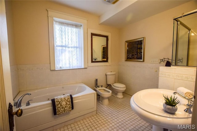 5076 Westminster Pl, Saint Louis, MO 63108 - full bathroom featuring a bidet, tile walls, a bath, toilet, and wainscoting