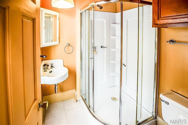 5076 Westminster Pl, Saint Louis, MO 63108 - bathroom featuring a stall shower, tile patterned flooring, toilet, baseboards, and a sink