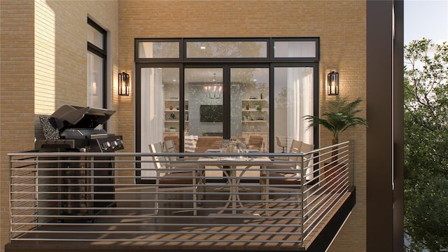 view of exterior entry featuring a balcony and brick siding