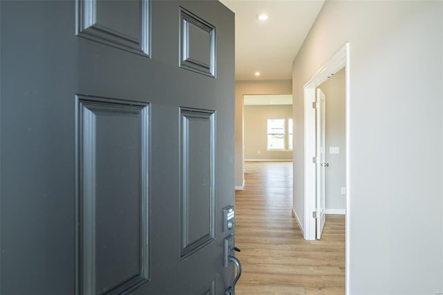 hall featuring light wood-style floors, recessed lighting, and baseboards