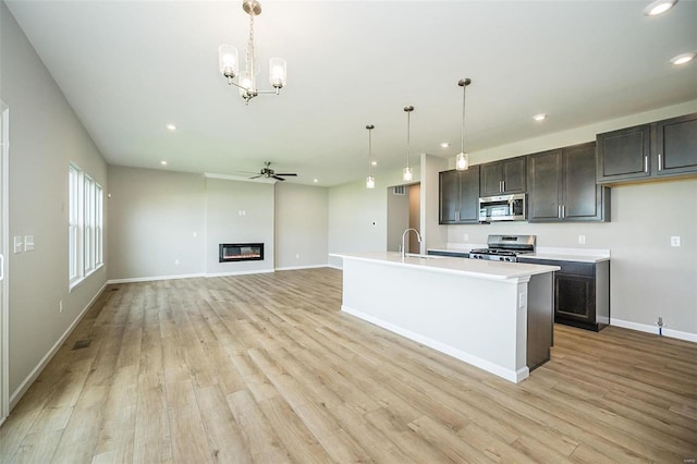 kitchen featuring stainless steel appliances, a ceiling fan, recessed lighting, light wood finished floors, and light countertops