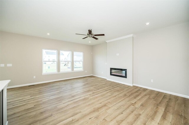 unfurnished living room with light wood finished floors, ceiling fan, baseboards, a glass covered fireplace, and recessed lighting