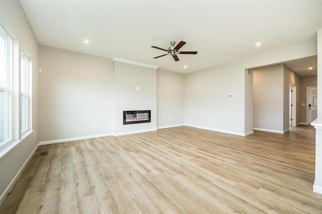 unfurnished living room featuring a ceiling fan, light wood-style floors, a glass covered fireplace, recessed lighting, and baseboards