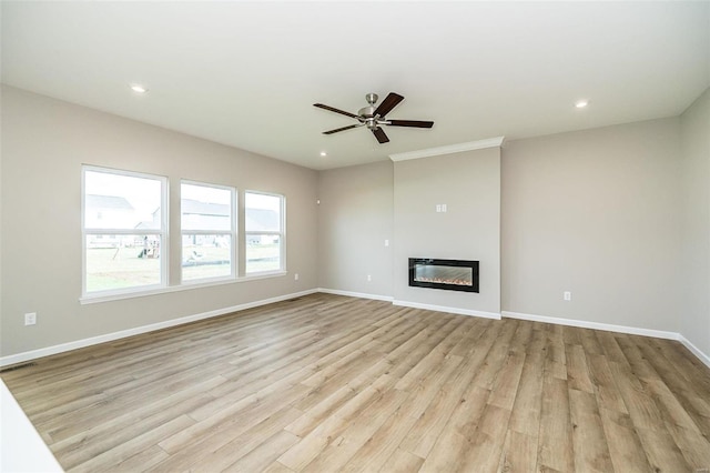 unfurnished living room with light wood-style flooring, ceiling fan, baseboards, recessed lighting, and a glass covered fireplace