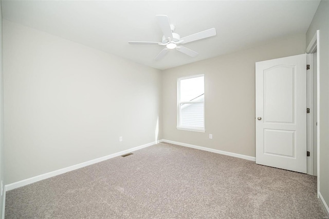 empty room with carpet floors, baseboards, and a ceiling fan