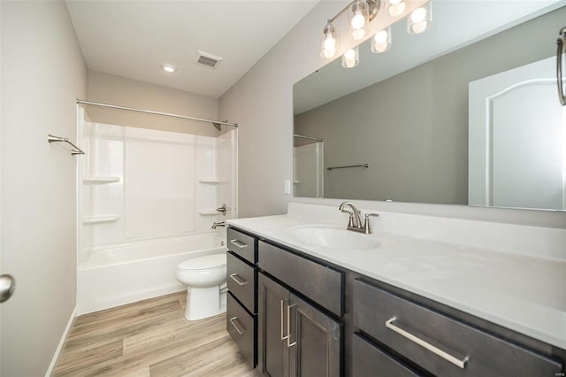 full bathroom featuring toilet, wood finished floors, vanity, tub / shower combination, and baseboards
