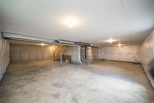 unfinished below grade area featuring heating unit and stairway