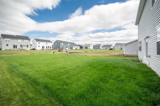 view of grassy yard featuring a residential view