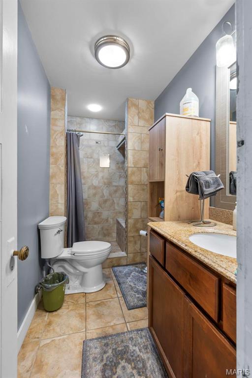 374 N Park Ave, Cape Girardeau, MO 63701 - bathroom with toilet, vanity, a tile shower, tile patterned flooring, and baseboards