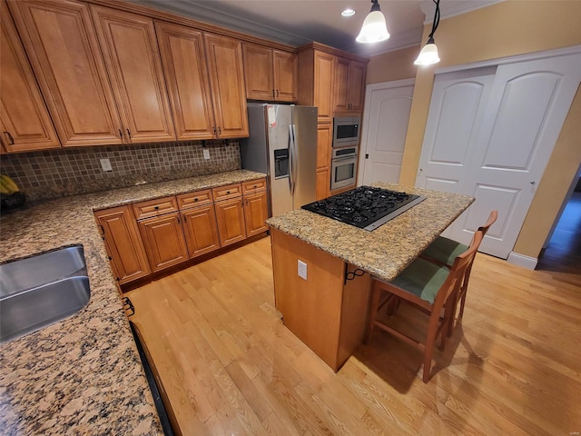 kitchen with stainless steel appliances, light wood-style floors, brown cabinets, and crown molding