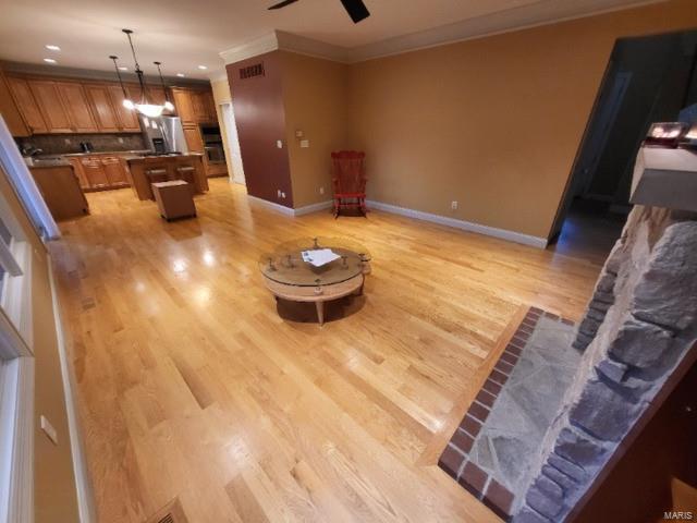 living room with crown molding, light wood-style flooring, ceiling fan, baseboards, and recessed lighting