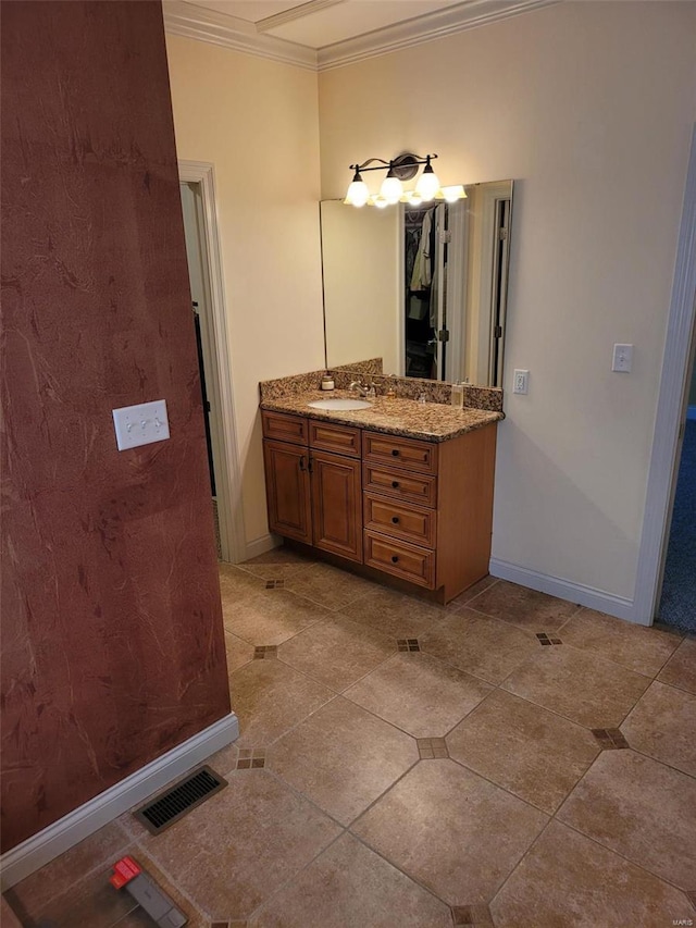 bathroom featuring ornamental molding, vanity, tile patterned flooring, and baseboards