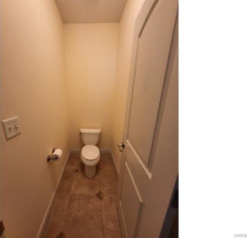 bathroom with toilet, tile patterned flooring, and baseboards