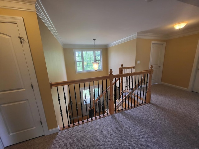 corridor with an upstairs landing, carpet, ornamental molding, and baseboards
