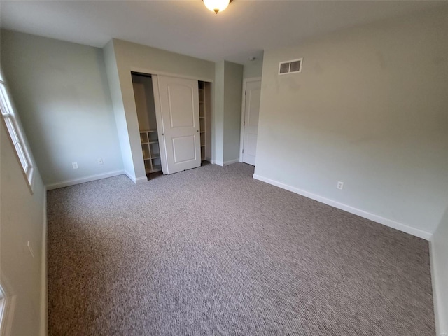 unfurnished bedroom with carpet, a closet, and baseboards