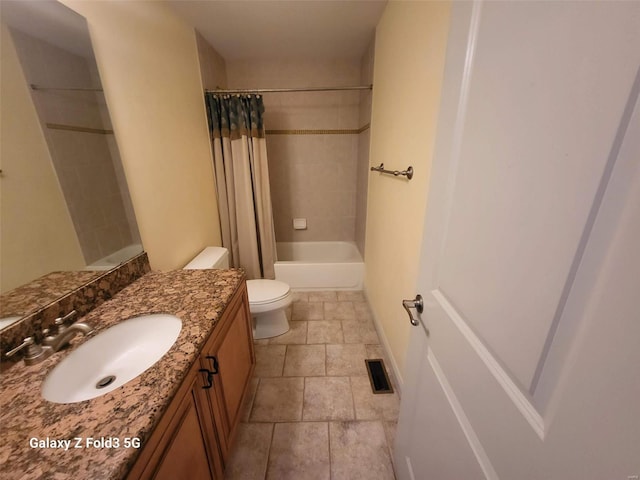 full bathroom featuring vanity, toilet, stone tile floors, and shower / bath combination with curtain