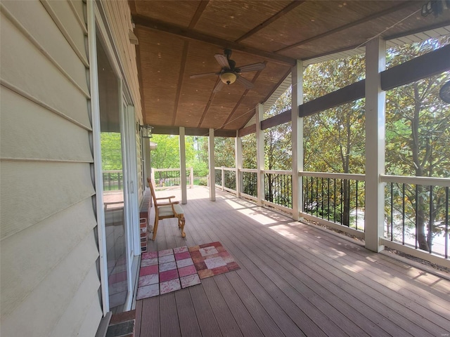 unfurnished sunroom featuring ceiling fan, plenty of natural light, and vaulted ceiling